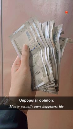 a person holding money in their hand with the caption unpopular opinion money actually buys happiness side