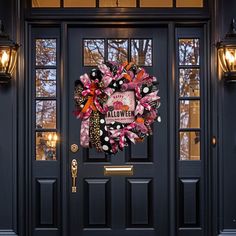 a black front door with a halloween wreath on it