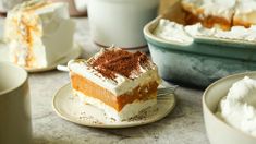 a piece of cake sitting on top of a white plate next to cups and saucers