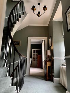 a hallway with stairs and pictures on the wall