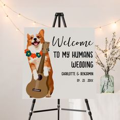 a welcome sign with a dog holding a ukulele on it's back