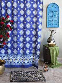 a potted plant sitting on top of a table next to a blue shower curtain