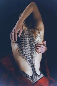 a woman with tattoos on her back