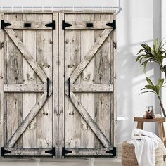 an open wooden door in a white room with a potted plant on the floor