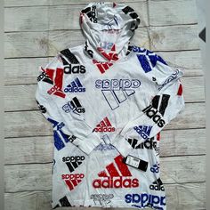 New With Tags Is A Long Sleeve T-Shirt With Sketchy Adidas Logos. - Size Large (14/16) - 100% Cotton Sporty Long Sleeve Hoodie With Graphic Print, Hooded Graphic Print Sports Tops, Casual Hoodie Tops With Logo Print, Casual Hooded Top With Graphic Print, Multicolor Long Sleeve Hoodie For Sports, Multicolor Hooded Tops With Graphic Print, Hooded Multicolor Tops With Graphic Print, Multicolor Graphic Print Hooded Top, White Cotton Hoodie Tops