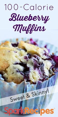 a blueberry muffin with crumbs in a paper wrapper on a white background