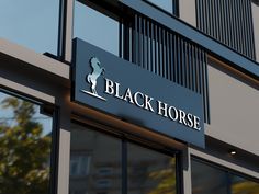 a black horse sign on the side of a building