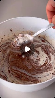 someone is mixing chocolate in a white bowl