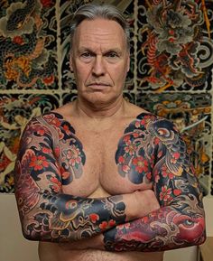 a man with tattoos on his arms and chest