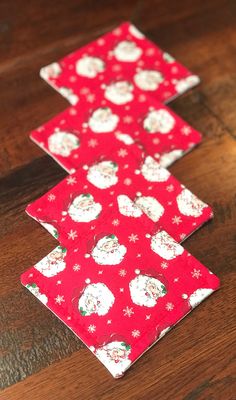 two red and white christmas trees sitting on top of a wooden table