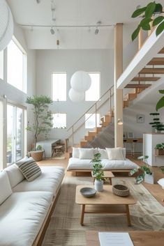 a living room filled with white furniture and lots of natural greenery on the walls