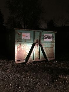 an old outhouse sitting in the dirt at night