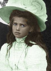 an old black and white photo of a woman wearing a hat with flowers on it