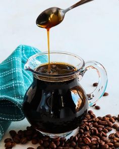 coffee being poured into a glass pitcher filled with coffee beans and the words, sweet coffee syrup