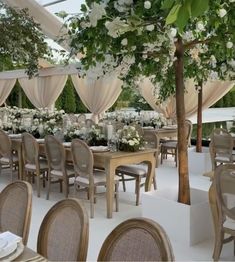 an outdoor dining area with tables, chairs and chandeliers set up for a formal function