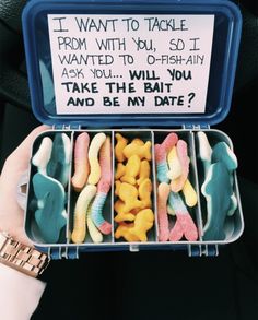 a person holding a container filled with fake fish and gummy bears next to a sign that says, i want to take from with you so i wanted to go