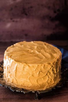 a frosted cake sitting on top of a glass plate