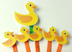 a bunch of little yellow ducks sitting on top of each other in front of a white wall