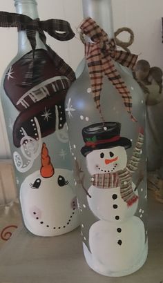 two glass bottles with snowmen painted on them