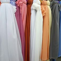 there are many dresses on display in the store, all different colors and styles to choose from