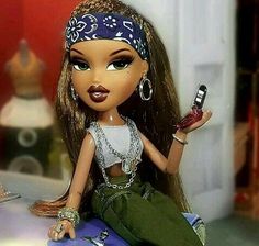 a doll sitting on top of a table with a cell phone in her hand and jewelry around her neck