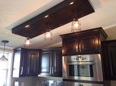 a kitchen with wooden cabinets and lights above the stove