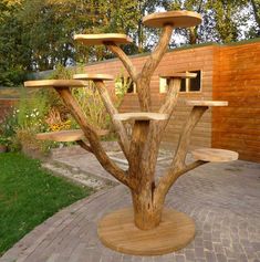 a wooden table with several shelves on it in the middle of a brick patio area