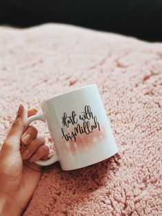 a person holding a coffee mug on top of a pink blanket with the words, not all happiness written on it