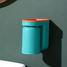 a wall mounted toothbrush dispenser next to a toilet