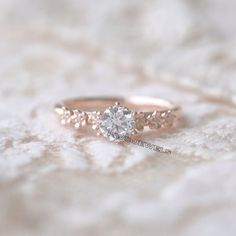 a close up of a diamond ring on a white surface