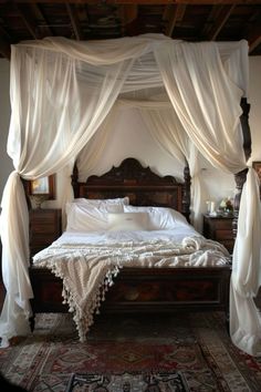 a canopy bed with white drapes over it