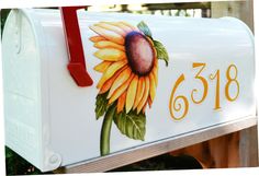 a white mailbox with a yellow flower painted on it