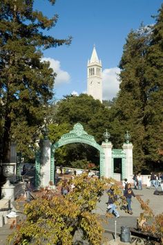 people are walking around in front of a clock tower