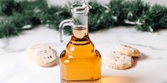 a glass bottle filled with liquid next to cookies