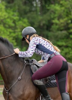 a woman riding on the back of a brown horse