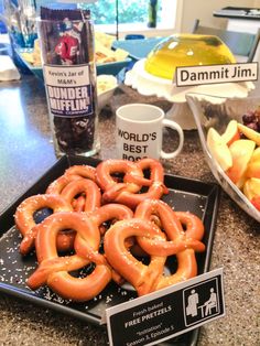 some pretzels are sitting on a tray next to fruit