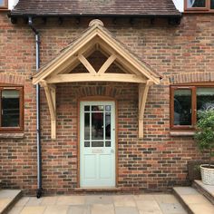 a brick house with a white front door and wooden frame on the side walk leading up to it's entrance