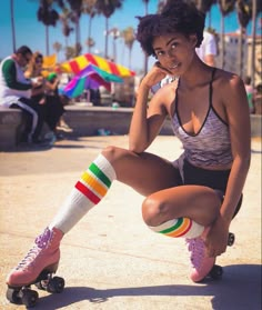 a woman sitting on top of a skateboard next to palm trees