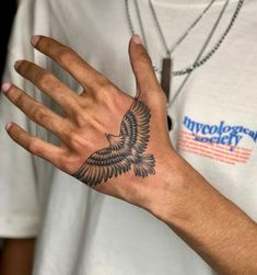 a person with a bird tattoo on their hand