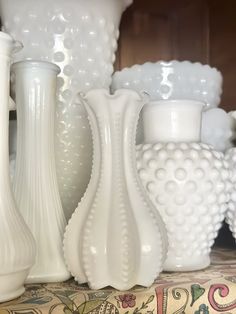 several white vases sitting on top of a table