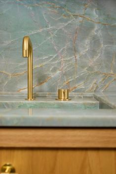 a gold faucet on a marble counter top