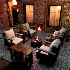 a fire pit sitting in the middle of a patio next to two couches and chairs