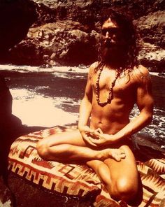 a man with long hair sitting on a raft in the water