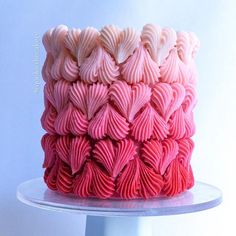 there is a cake that has pink and white icing on the top of it