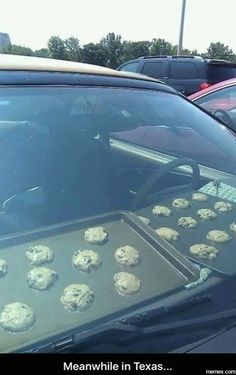 there are many cookies on the tray in the back of this car and it is ready to be put into the oven