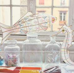 paper fish and other craft supplies on a window sill