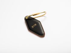 a black and gold leather case with the initials byr on it, sitting on a white surface