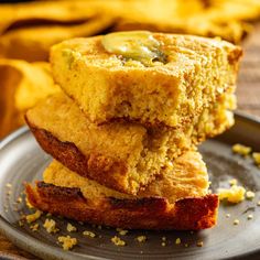 three cornbreads stacked on top of each other on a plate next to chips