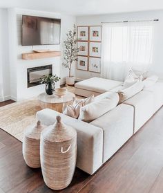 a living room filled with furniture and a flat screen tv mounted on the wall above a fire place