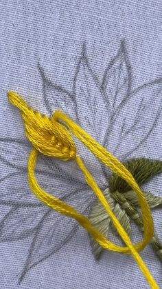 a close up of some yellow thread on a piece of cloth